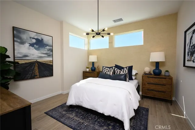 a bedroom with bed and a painting on the wall