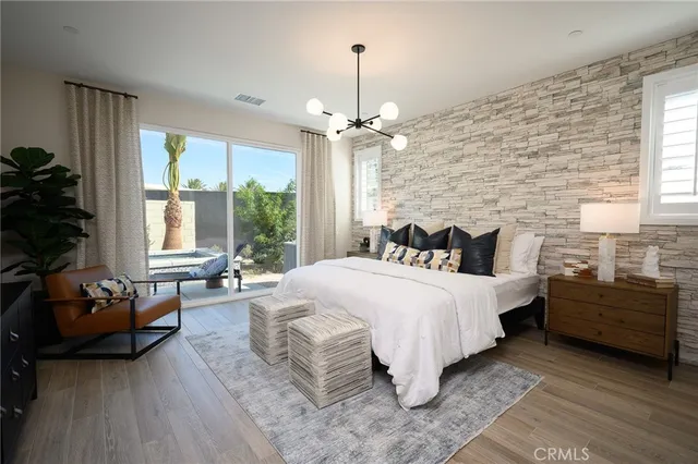 a spacious bedroom with a bed a chandelier and a window