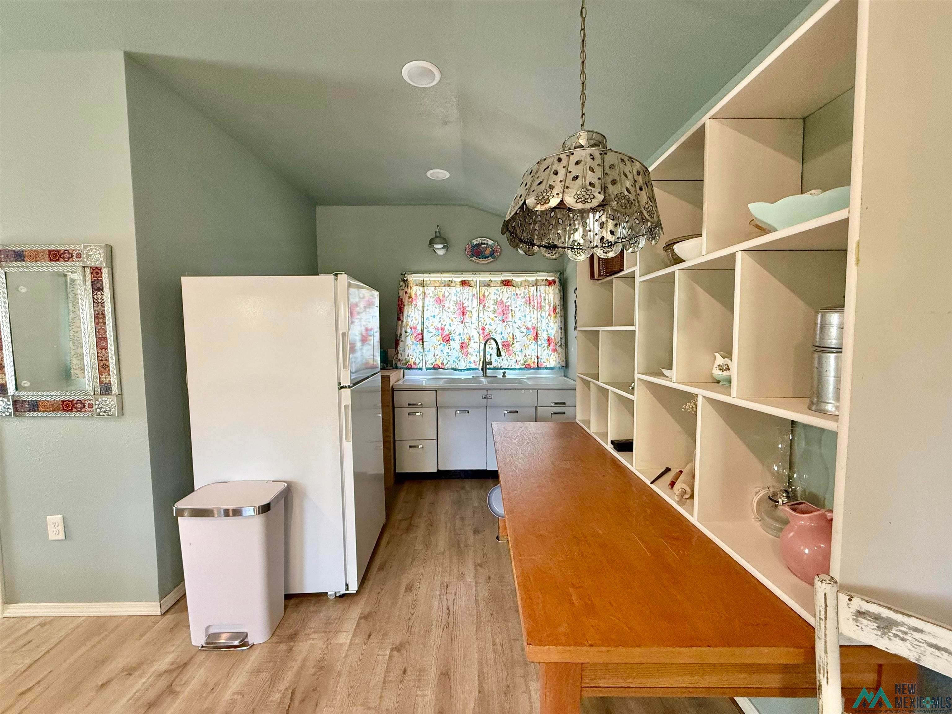 625 South 5th Street Raton, NM 87740 - Photo 30 of 45 Kitchen featuring freestanding refrigerator, light wood finished floors, a chandelier, and vaulted ceiling