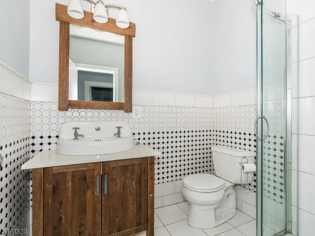 a bathroom with a toilet sink vanity and mirror