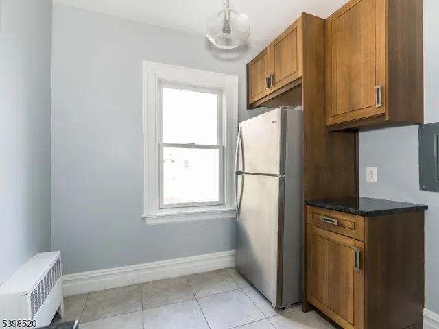 a kitchen with granite countertop cabinets and refrigerator