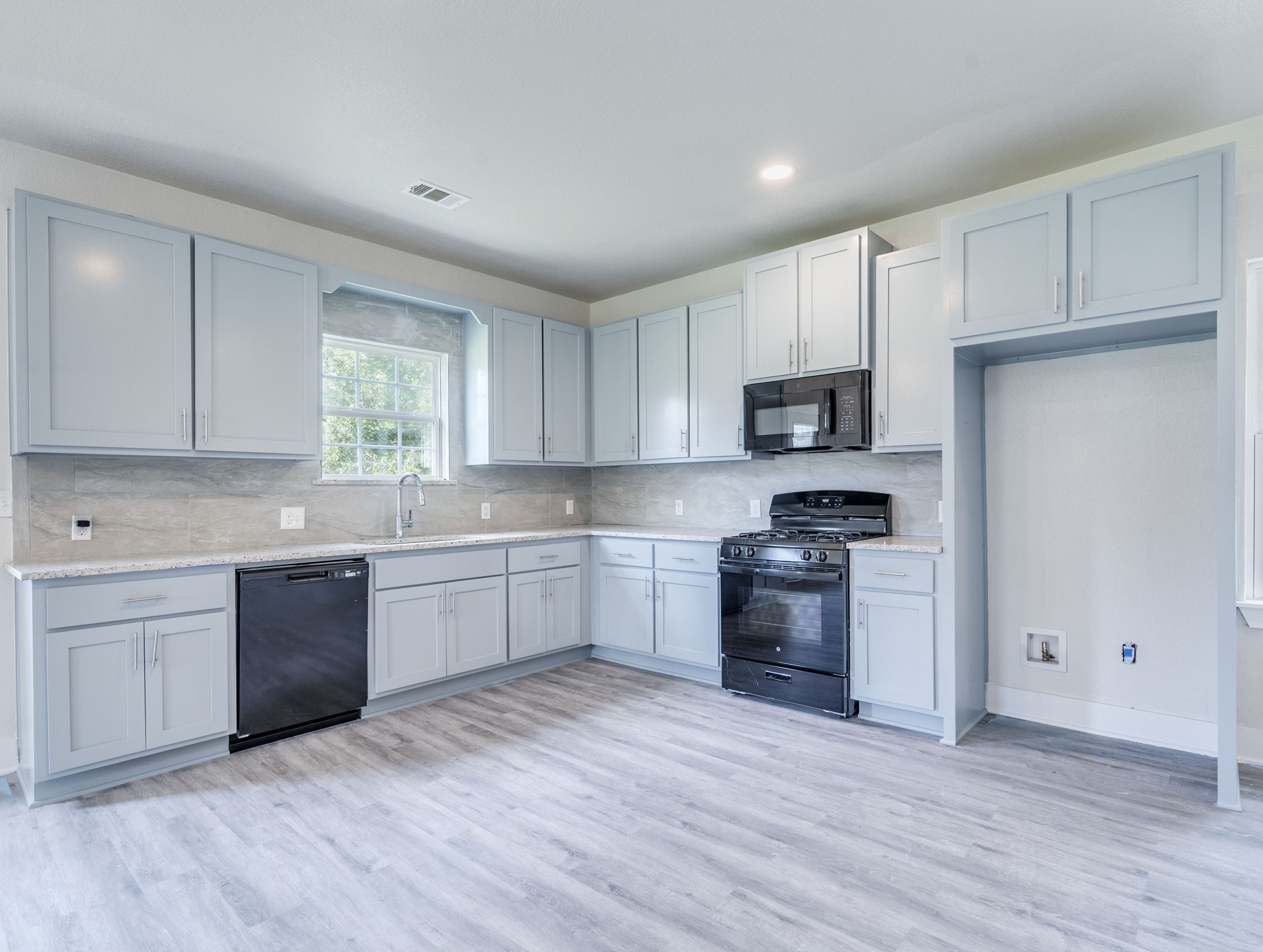 a kitchen with wooden floors and stainless steel appliances