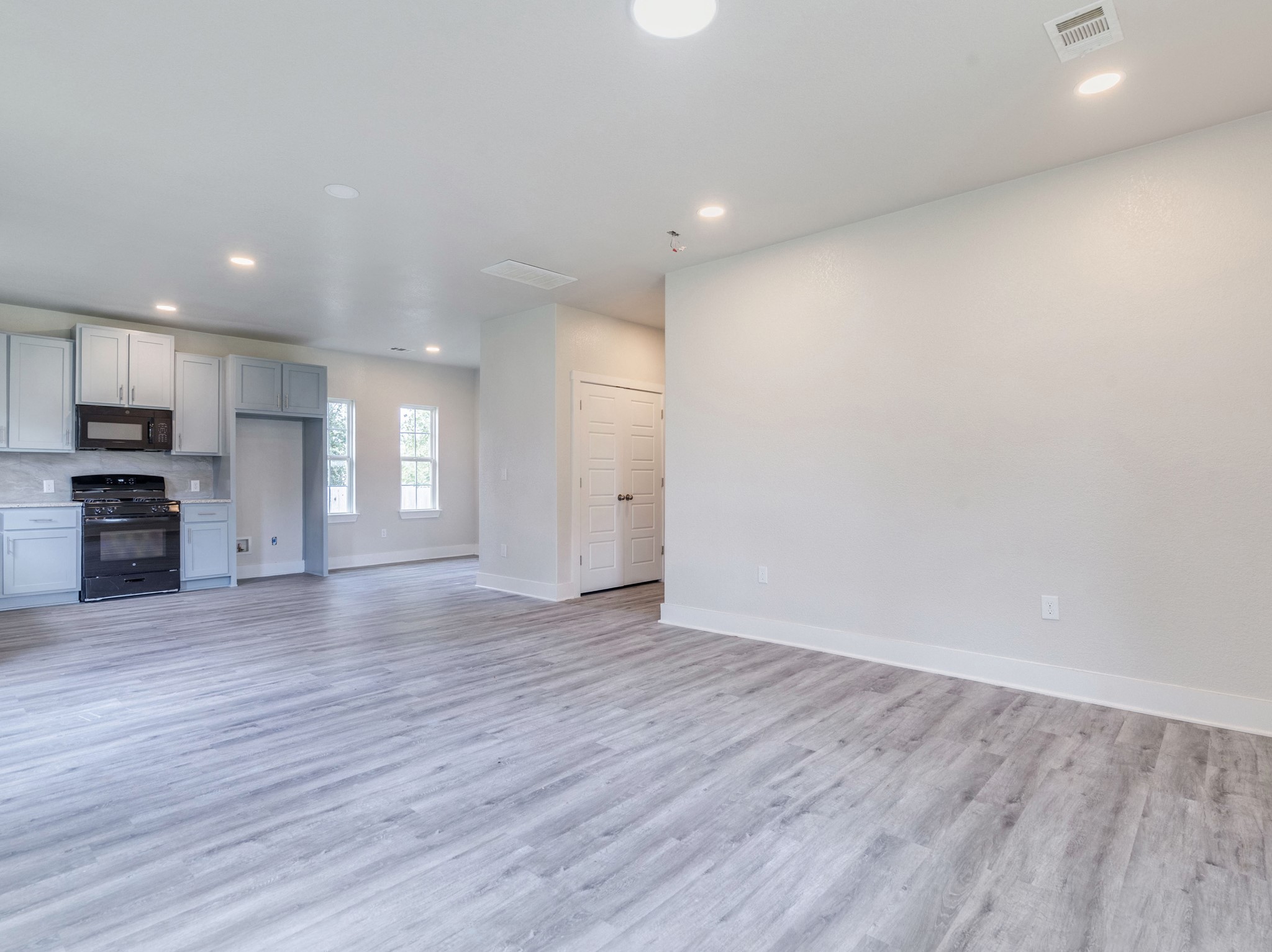 411 South Ave B Elgin, TX 78621 - Photo 4 of 23 an empty room with wooden floor and windows