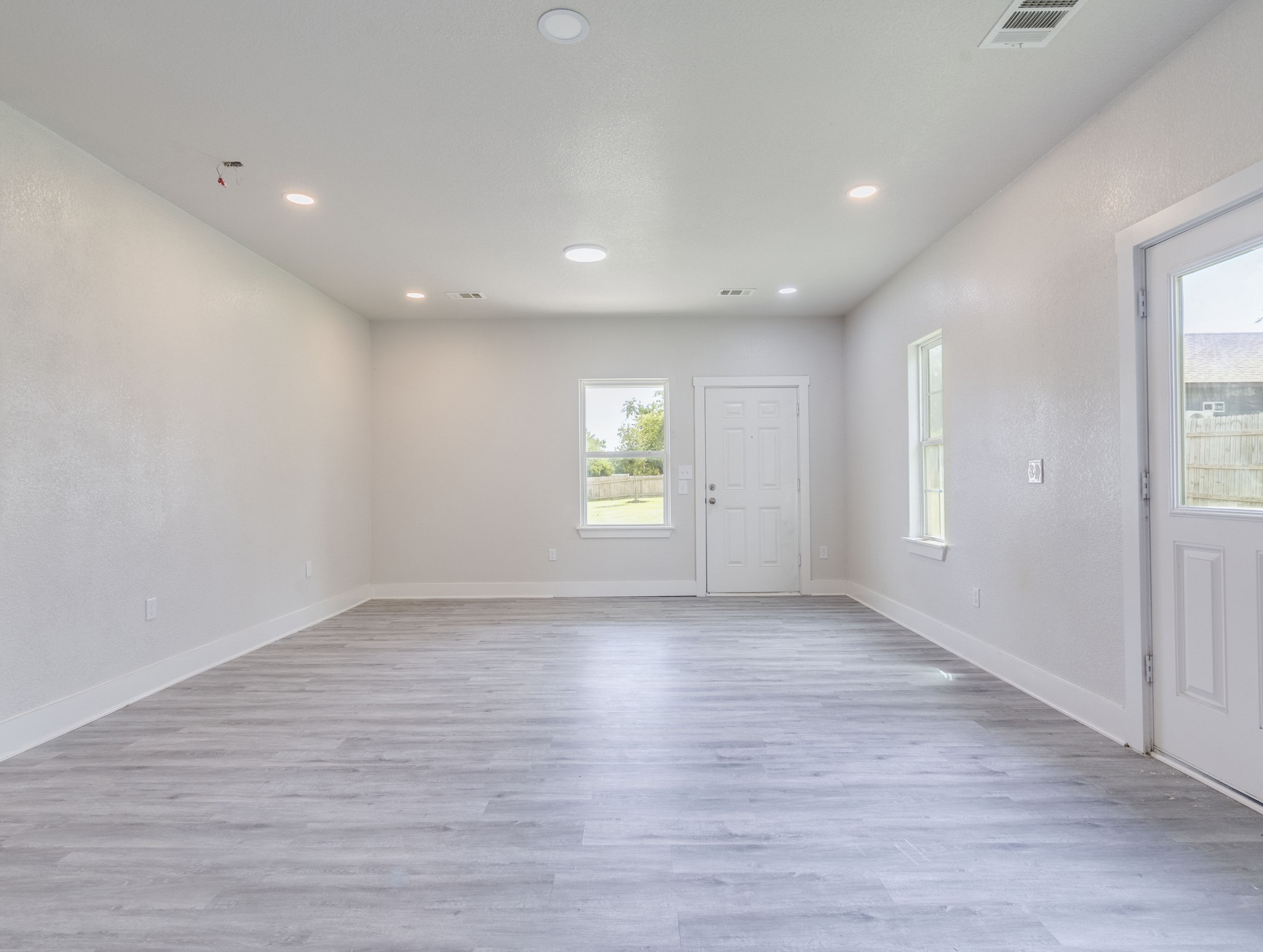 411 South Ave B Elgin, TX 78621 - Photo 6 of 23 an empty room with wooden floor and windows