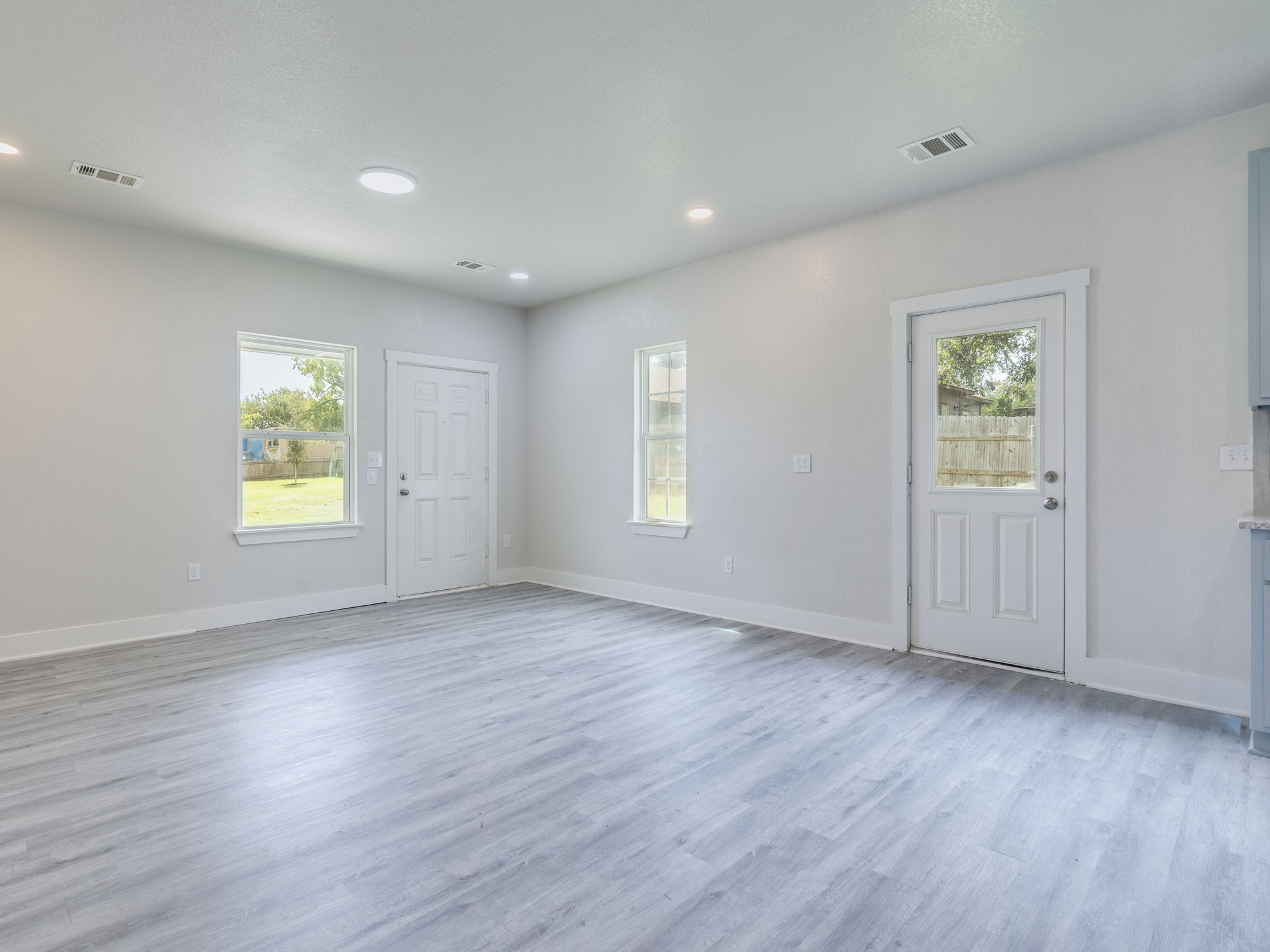 411 South Ave B Elgin, TX 78621 - Photo 7 of 23 an empty room with wooden floor and windows