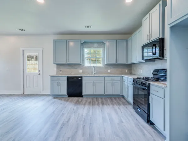 a kitchen with stainless steel appliances sink cabinets and wooden floor