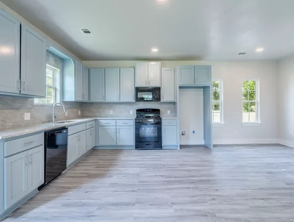 a kitchen with a refrigerator and a stove top oven