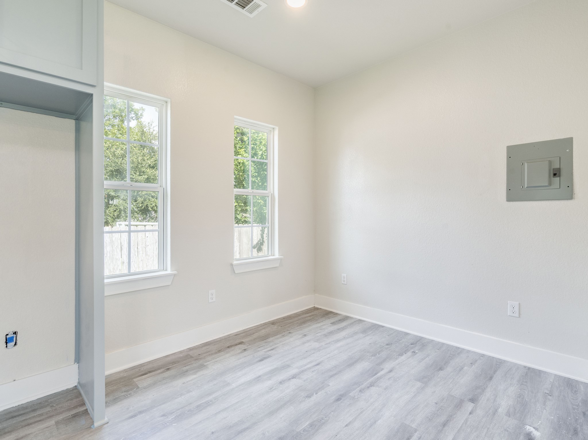 411 South Ave B Elgin, TX 78621 - Photo 10 of 23 an empty room with wooden floor and windows