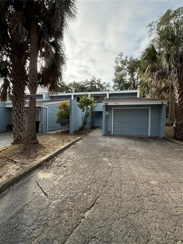 a view of a house with a backyard and a tree
