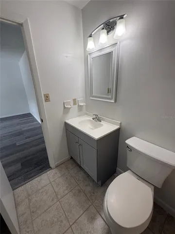 a view of an empty room with wooden floor and closet