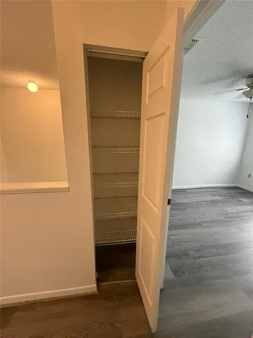 an empty room with wooden floor chandelier fan and windows