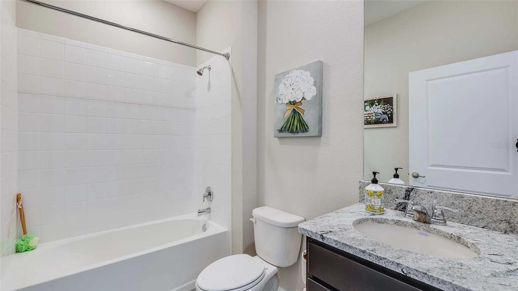 4319 Fence Row Court Lakewood Ranch, FL 34211 - Photo 11 of 39 a bathroom with a granite countertop sink toilet and bathtub