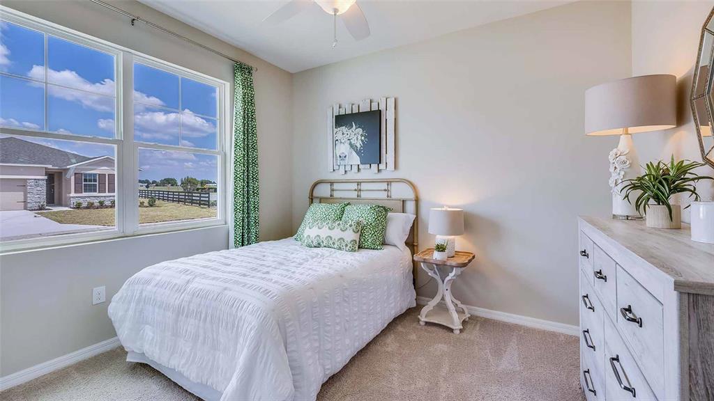 4319 Fence Row Court Lakewood Ranch, FL 34211 - Photo 9 of 39 a bedroom with a large bed and a lamp on dresser