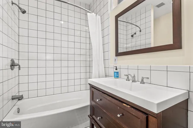 a bathroom with a sink mirror and a bathtub