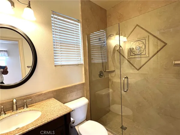 a bathroom with a granite countertop sink toilet and shower