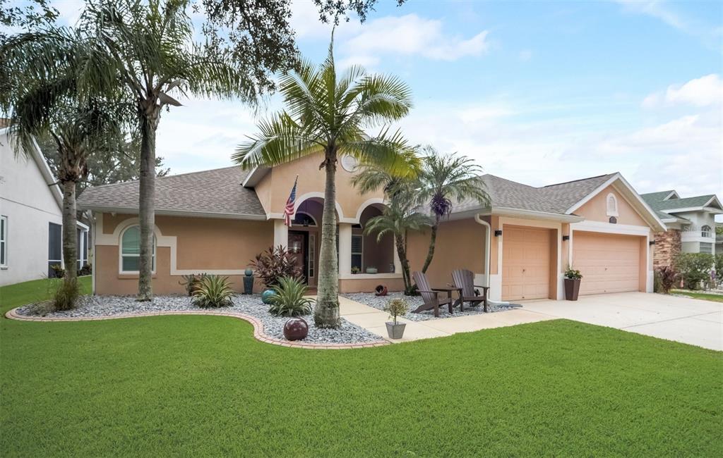 a view of a house with a yard and palm trees