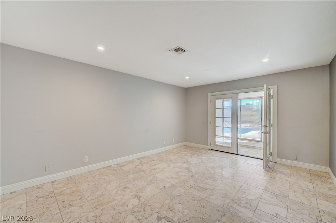6635 Costa Brava Road Las Vegas, NV 89146 - Photo 25 of 59 Step into this luminous living area, offering seamless outdoor access through French doors to a private pool.