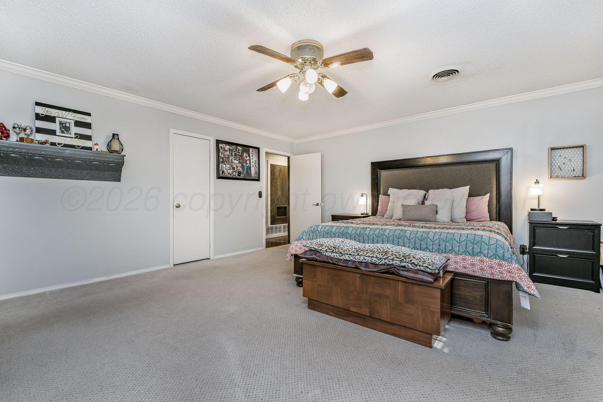 801 Arrah Friona, TX 79035 - Photo 12 of 37 a bedroom with a bed and a chandelier