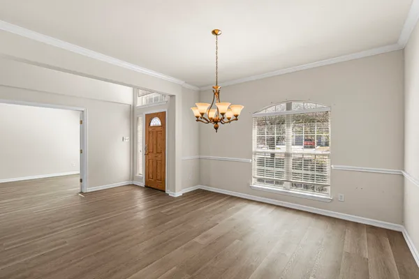 a view of a room with wooden floor staircase and a chandelier