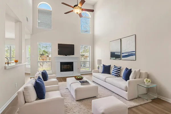 a view of an empty room with wooden floor and a fireplace