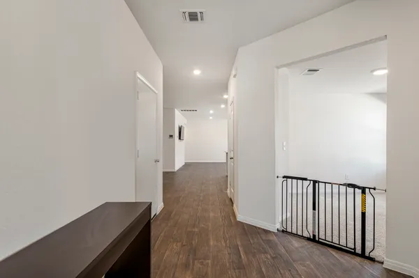 a view of a hallway with wooden floor