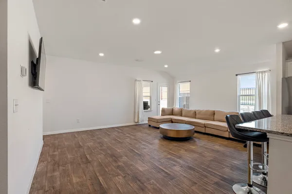 a living room with furniture and a wooden floor