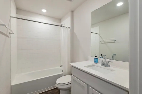 a bathroom with a granite countertop sink a toilet and shower