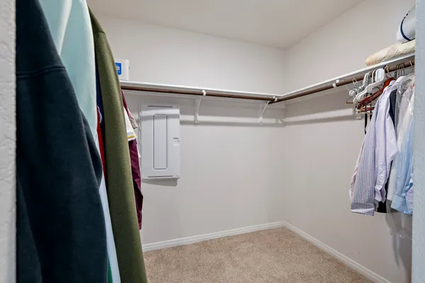 a view of walk in closet with clothes and shoes