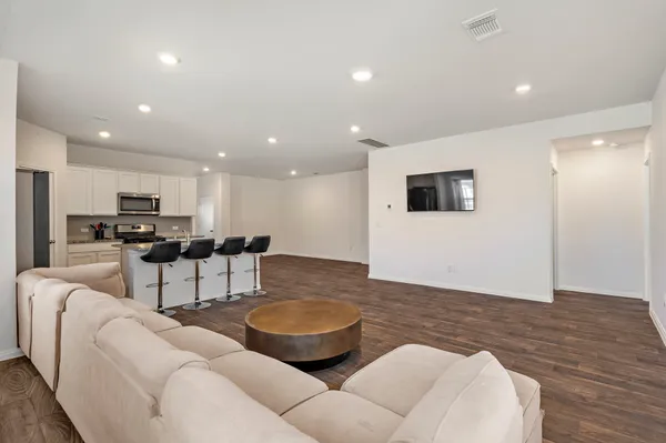 a living room with furniture and view of kitchen