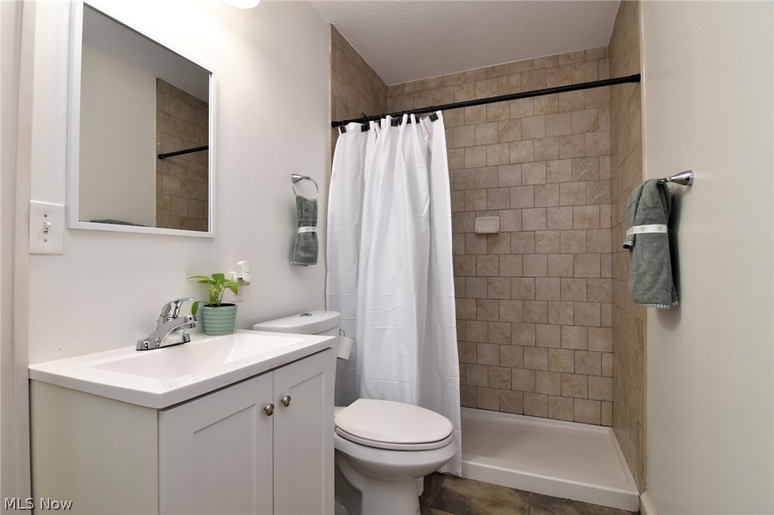 3584 Pennington Road Cleveland, OH 44120 - Photo 28 of 42 Bathroom featuring curtained shower, vanity, toilet, and tile floors