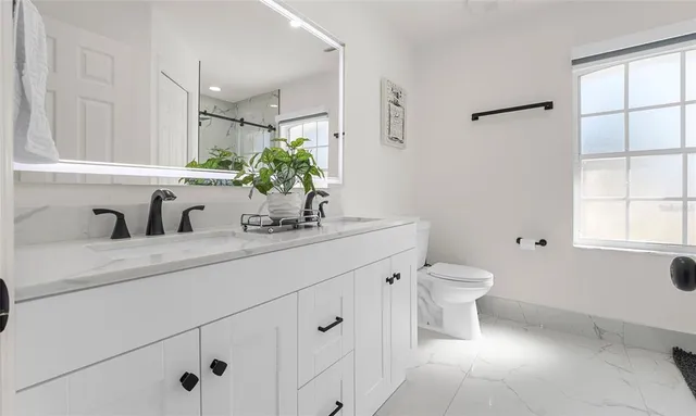a bathroom with a toilet sink and mirror