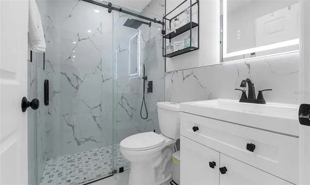 a bathroom with a sink a toilet and shower