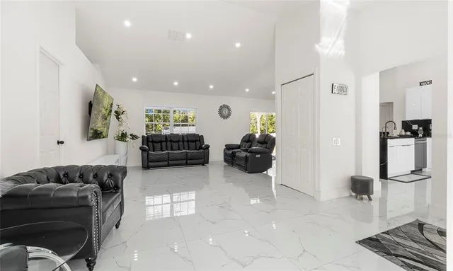 a living room with furniture and a refrigerator