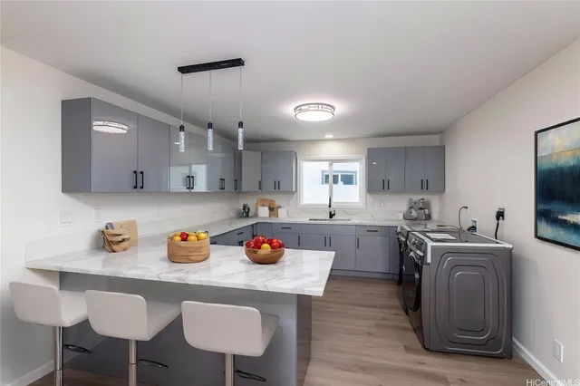 a kitchen with a sink a stove cabinets and wooden floor