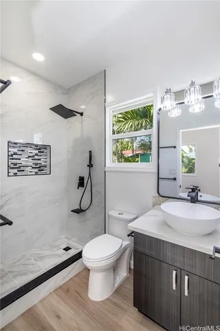 a bathroom with a granite countertop toilet sink and mirror