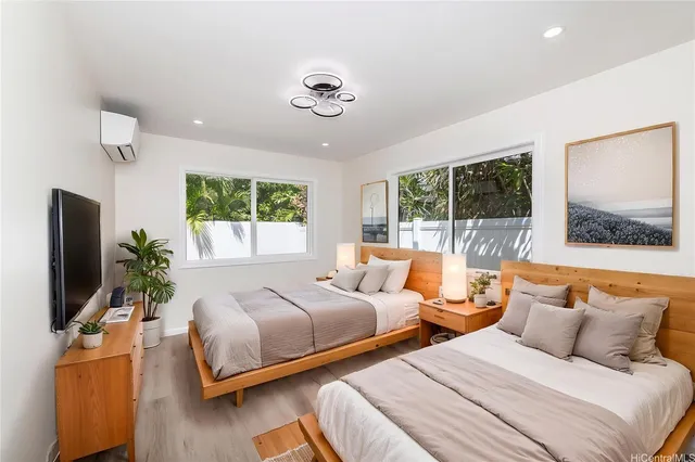 a bedroom with two large bed and a flat screen tv