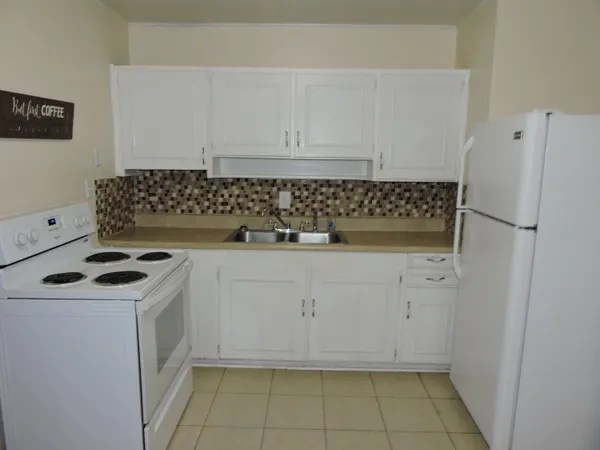 a kitchen with white cabinets and white appliances