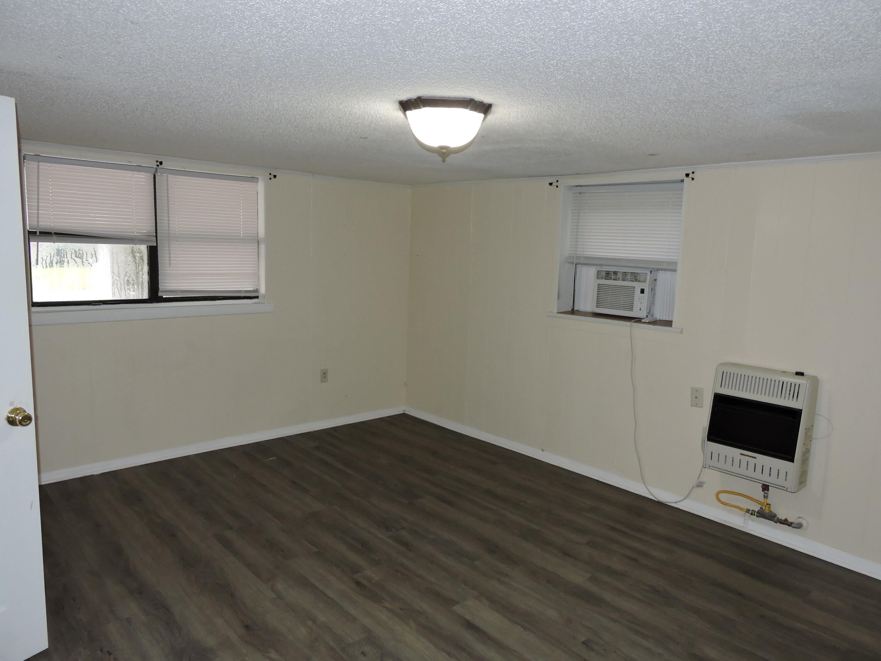 120 Sikes Drive Crestview, FL 32539 - Photo 7 of 18 a view of an empty room with wooden floor and a window