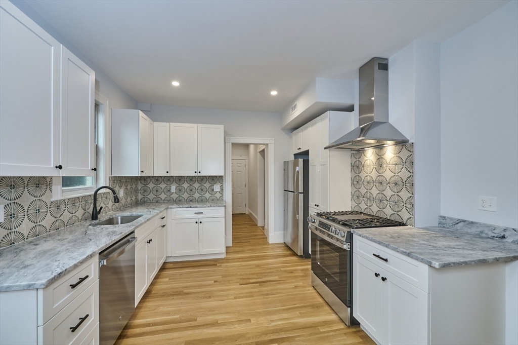 a large kitchen with a stove and a sink