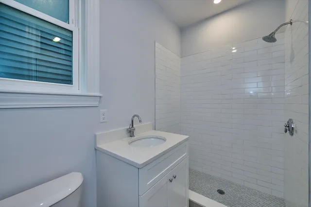 a bathroom with a sink a toilet and shower