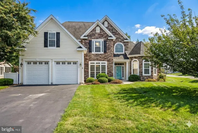 an aerial view of a house with swimming pool and large trees