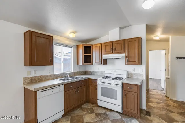 a kitchen with stainless steel appliances granite countertop a stove sink and cabinets