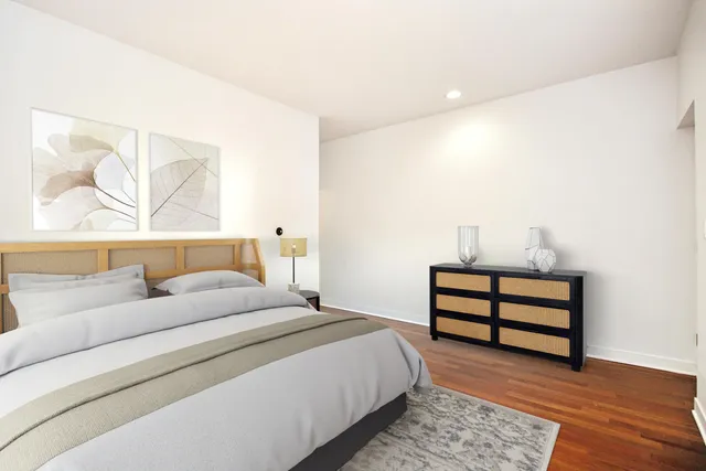 a bedroom with a bed and a painting on the wall