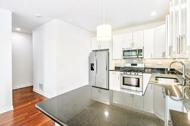 a kitchen with stainless steel appliances a refrigerator sink and microwave