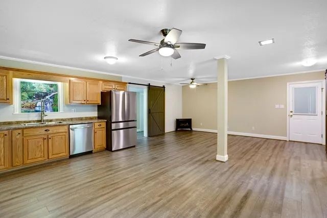 a kitchen with granite countertop stainless steel appliances a refrigerator sink and microwave