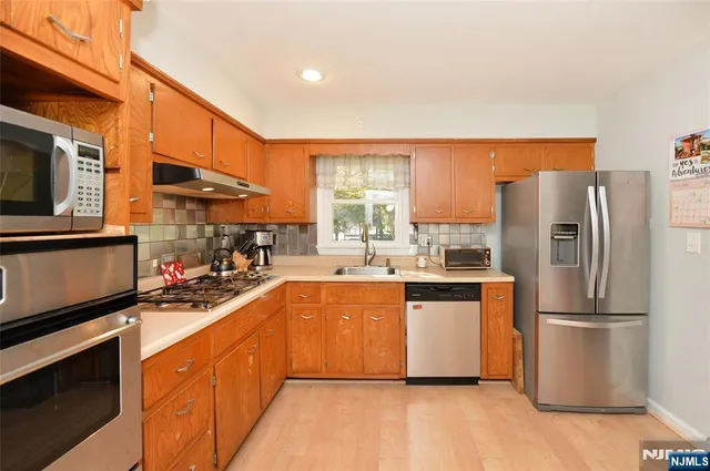 a kitchen with stainless steel appliances a refrigerator sink and microwave