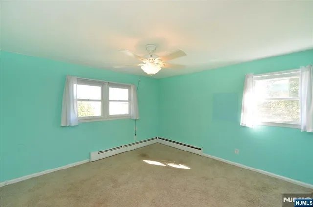 an empty room with a window and a fan
