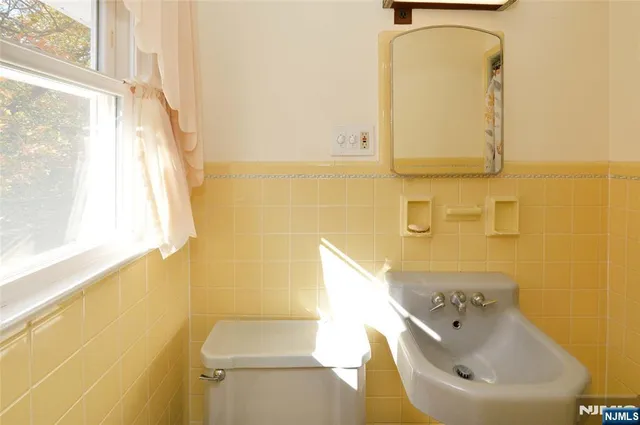 a bathroom with a sink a toilet and mirror