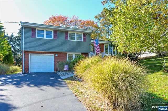 a front view of house with yard and trees around