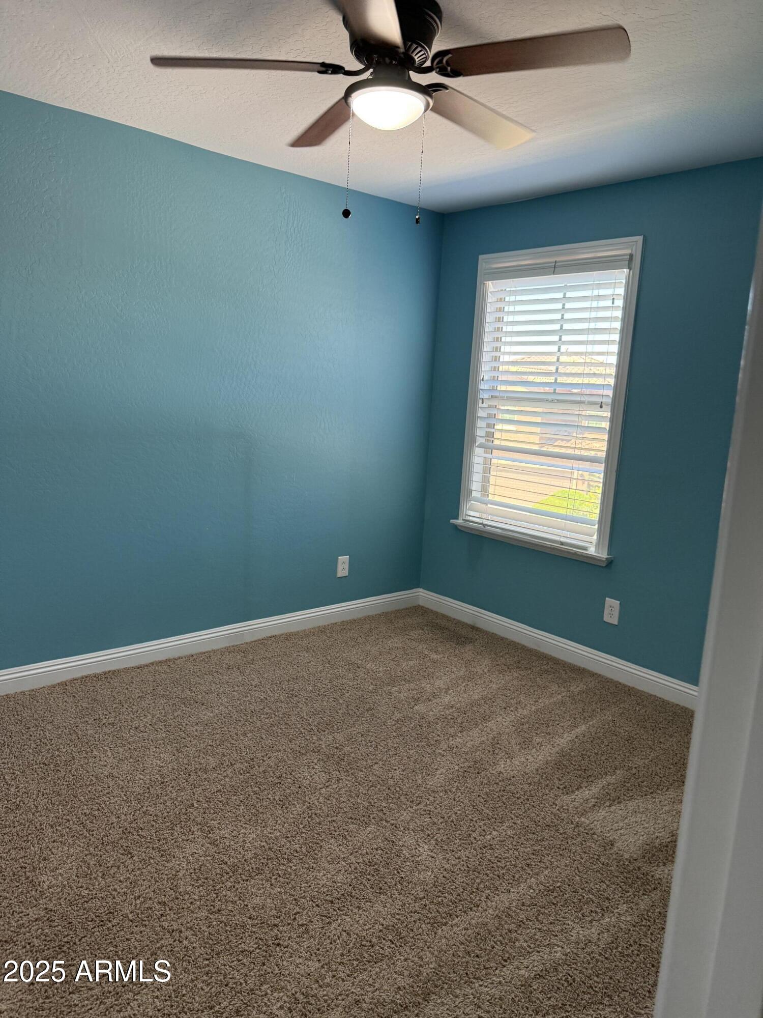 1843 West Fetlock Trail Phoenix, AZ 85085 - Photo 21 of 36 an empty room with a window and a fan